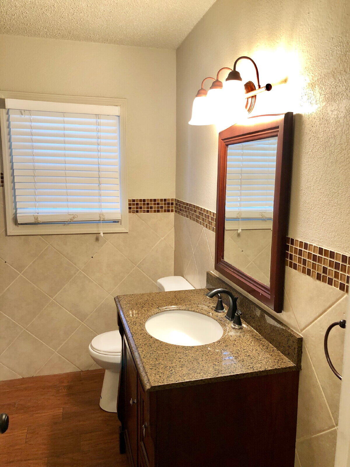 3412 30th Street Lubbock, TX 79410 - Photo 9 of 14 a bathroom with a granite countertop sink and a mirror