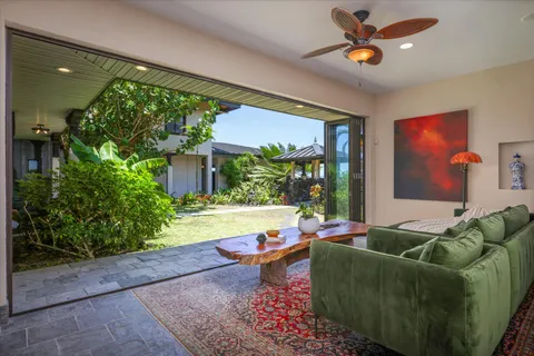 a living room with patio furniture and a floor to ceiling window