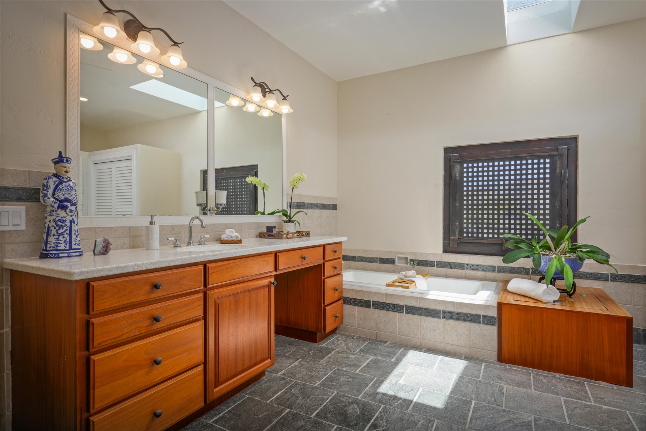 95-4667 Hawaii Belt Road Naalehu, HI 96772 - Photo 21 of 30 a spacious bathroom with a double vanity sink a large mirror and a bathtub