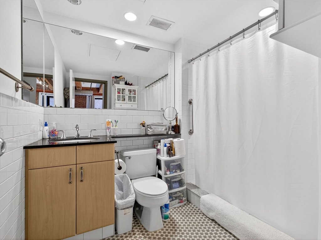 9 West Broadway, Unit 206 Boston, MA 02127 - Photo 12 of 25 a bathroom with a granite countertop sink mirror vanity and toilet