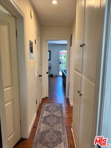 a view of a hallway with wooden floor and closet area