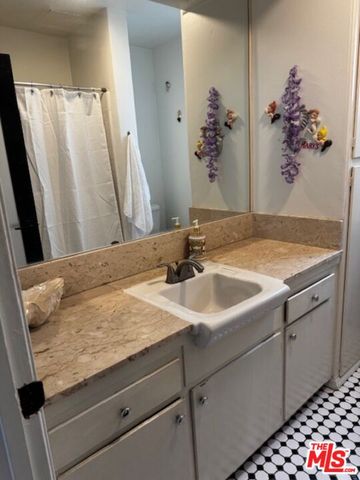 a bathroom with a granite countertop sink a large mirror and a shower