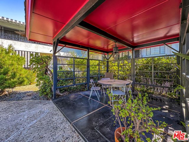 a patio with table and chairs and potted plants