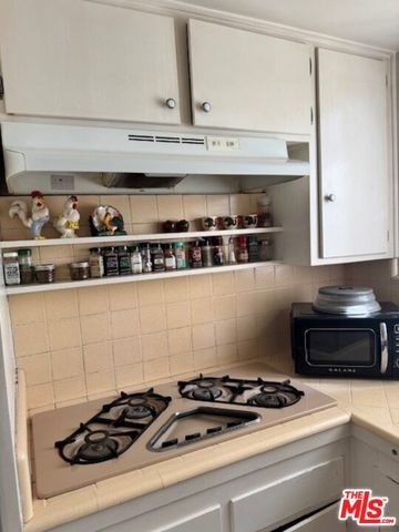 a white stove top oven sitting inside of a kitchen