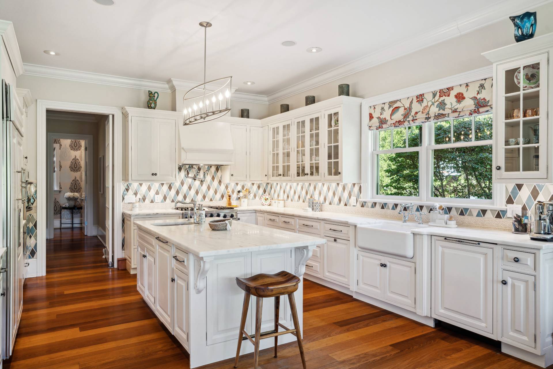25 Jordan Drive Water Mill, NY 11976 - Photo 11 of 43 a large white kitchen with cabinets a sink dishwasher a dining table and chairs with wooden floor