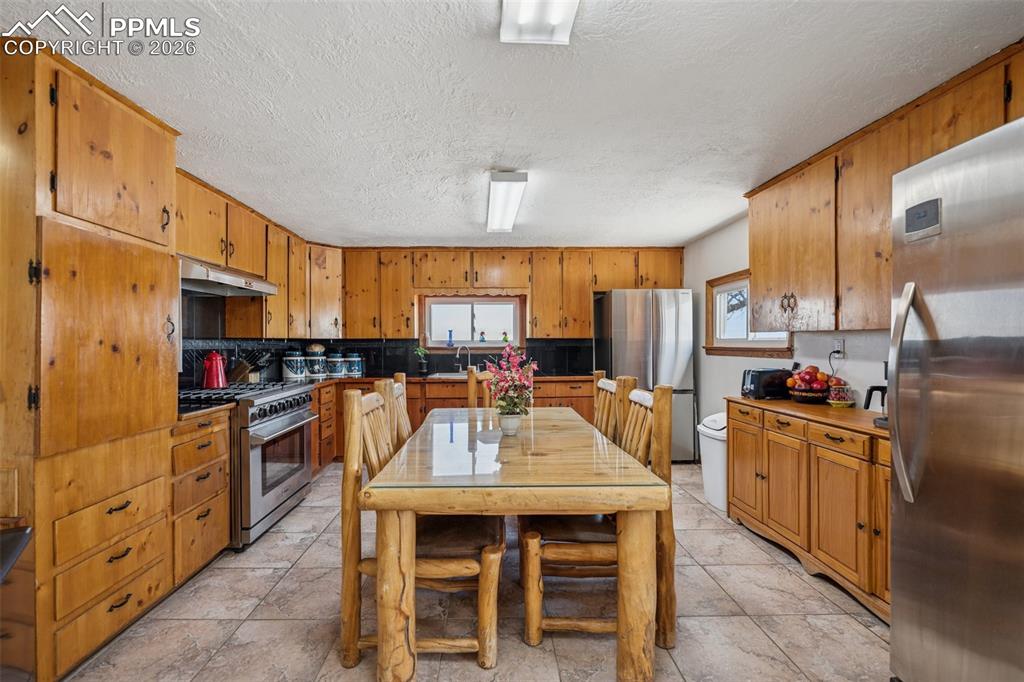 6771 Boone Road Boone, CO 81025 - Photo 13 of 49 a kitchen with stainless steel appliances kitchen island granite countertop a table chairs and a refrigerator