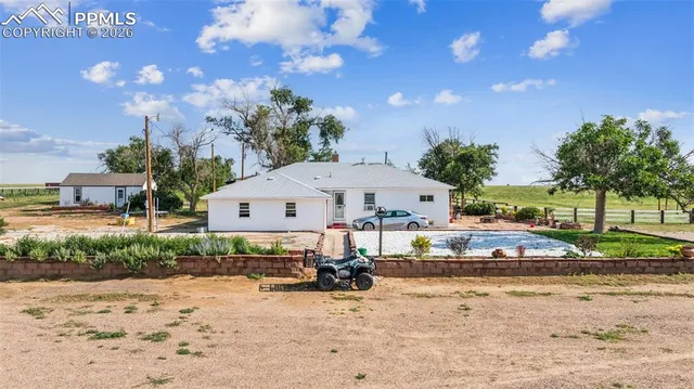 a view of a house with a yard and sitting area