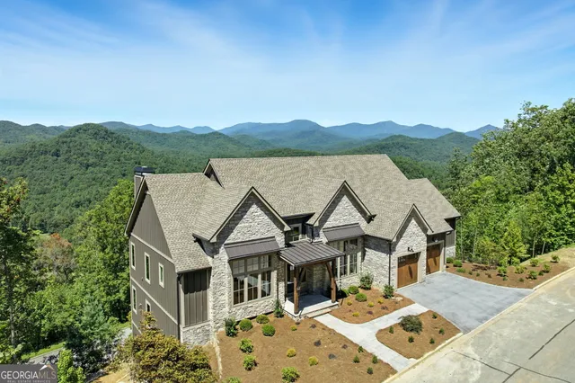 a view of house with yard and mountain view in back