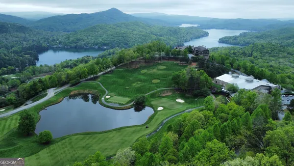 a view of a house with a street lush green forest