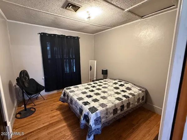 a bedroom with a bed and wooden floor