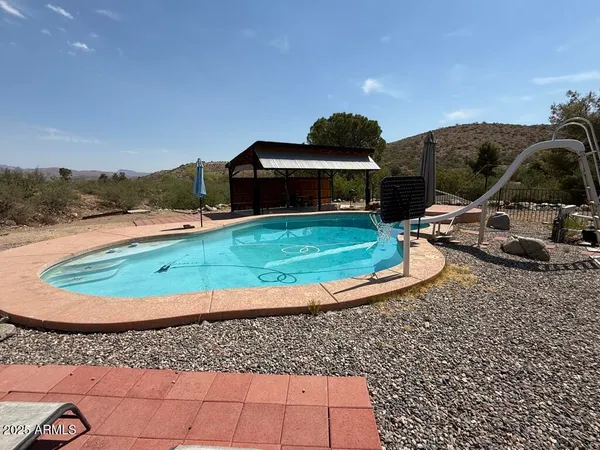 a view of a house with swimming pool and yard