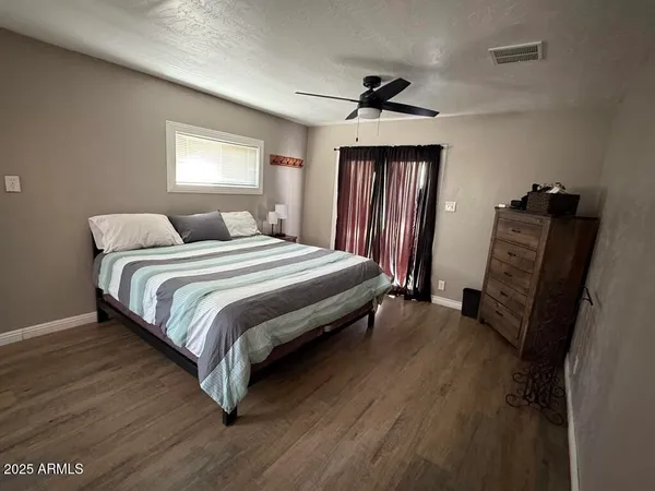 a bedroom with a bed wooden floor and window