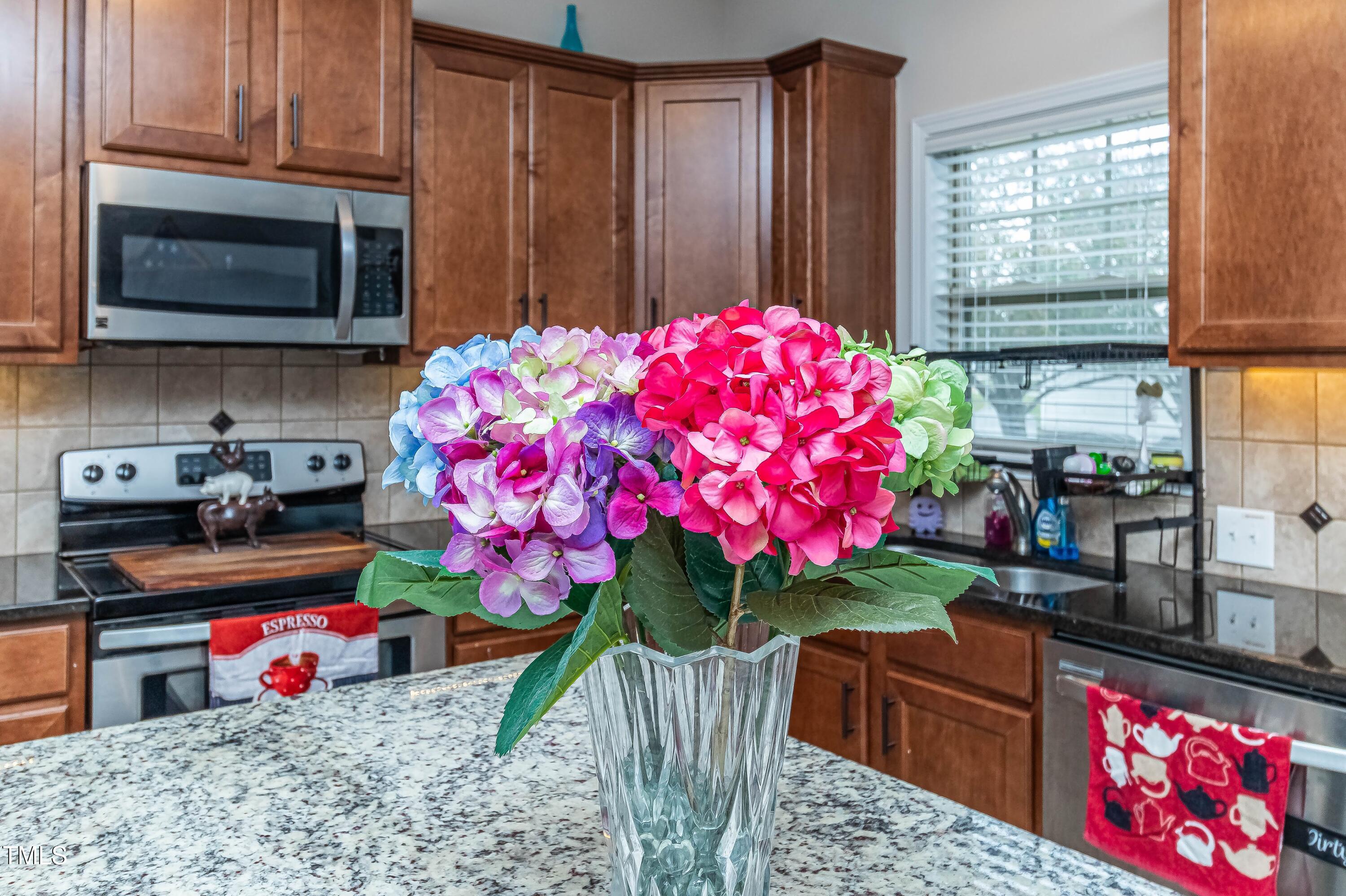 1852 Alderman Mill Road Dunn, NC 28334 - Photo 11 of 36 a kitchen with stainless steel appliances granite countertop a kitchen island a stove and a wooden cabinets