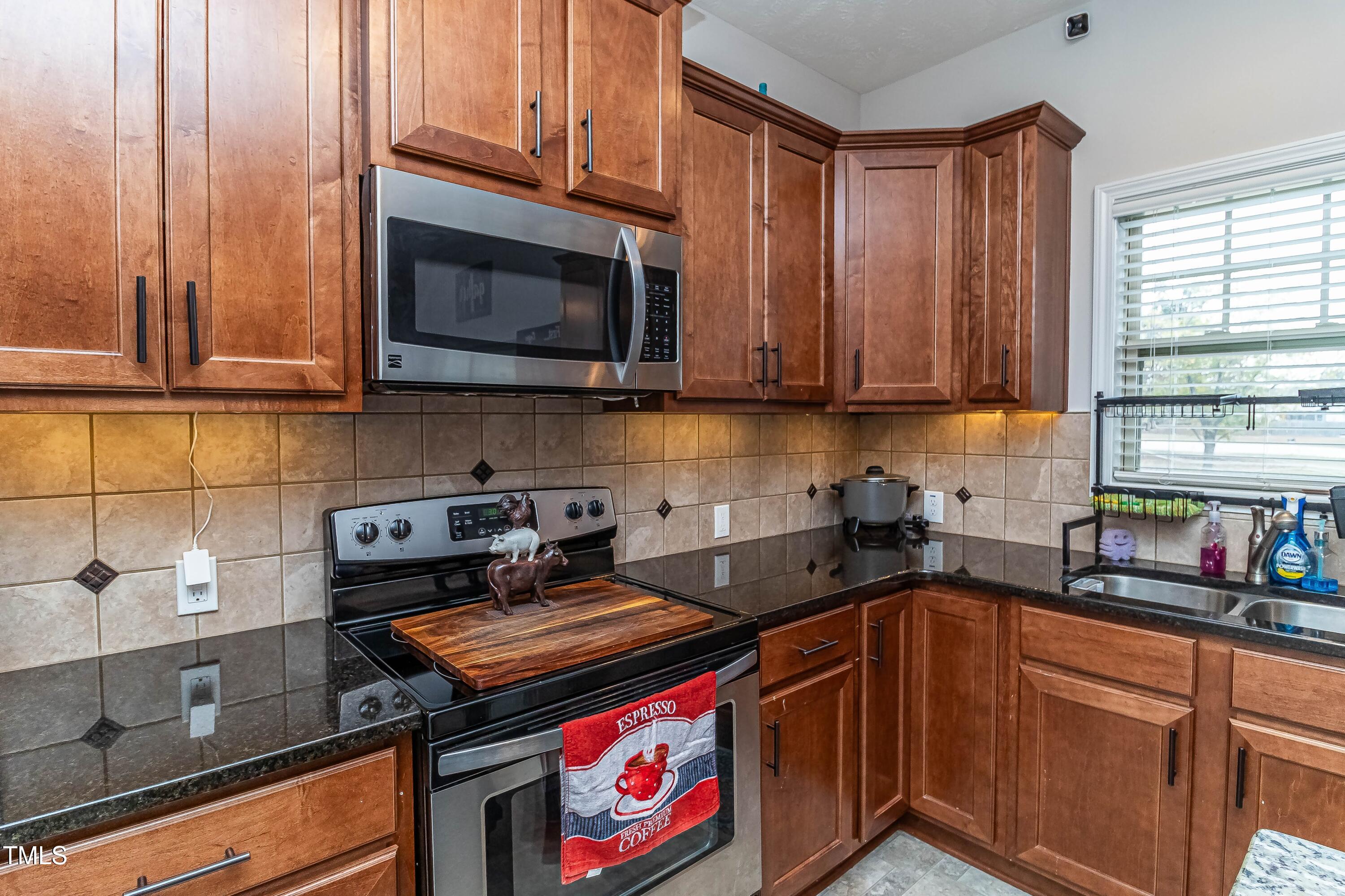 1852 Alderman Mill Road Dunn, NC 28334 - Photo 13 of 36 a kitchen with stainless steel appliances granite countertop a stove a sink and a microwave