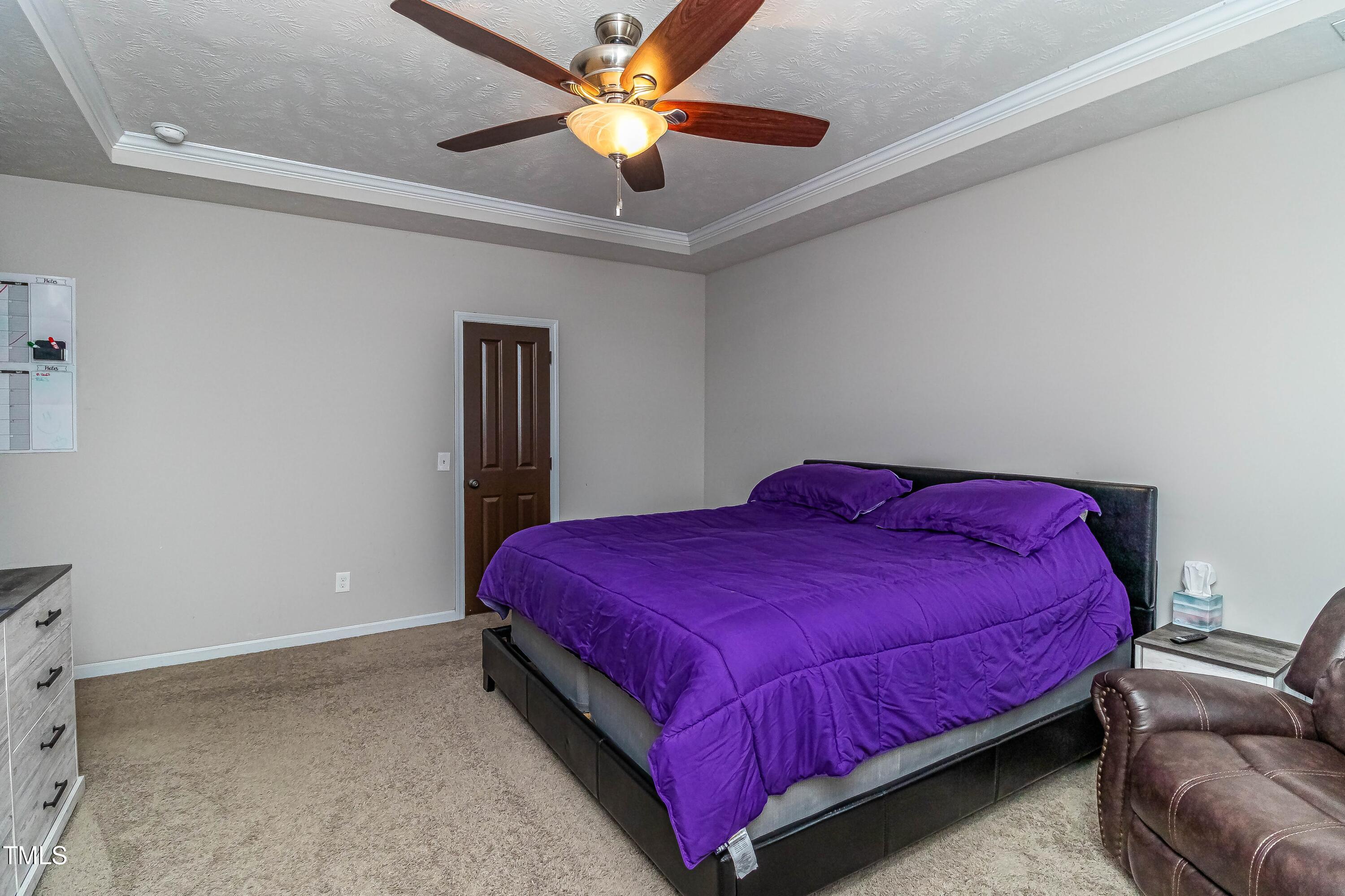 1852 Alderman Mill Road Dunn, NC 28334 - Photo 25 of 36 a bedroom with a bed and a chandelier