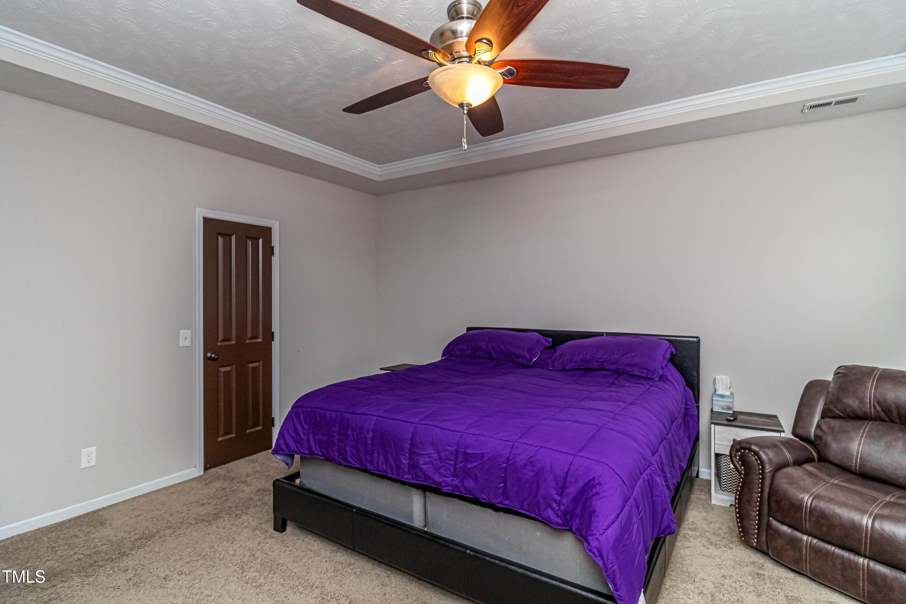 1852 Alderman Mill Road Dunn, NC 28334 - Photo 26 of 36 a bedroom with a bed and a chandelier