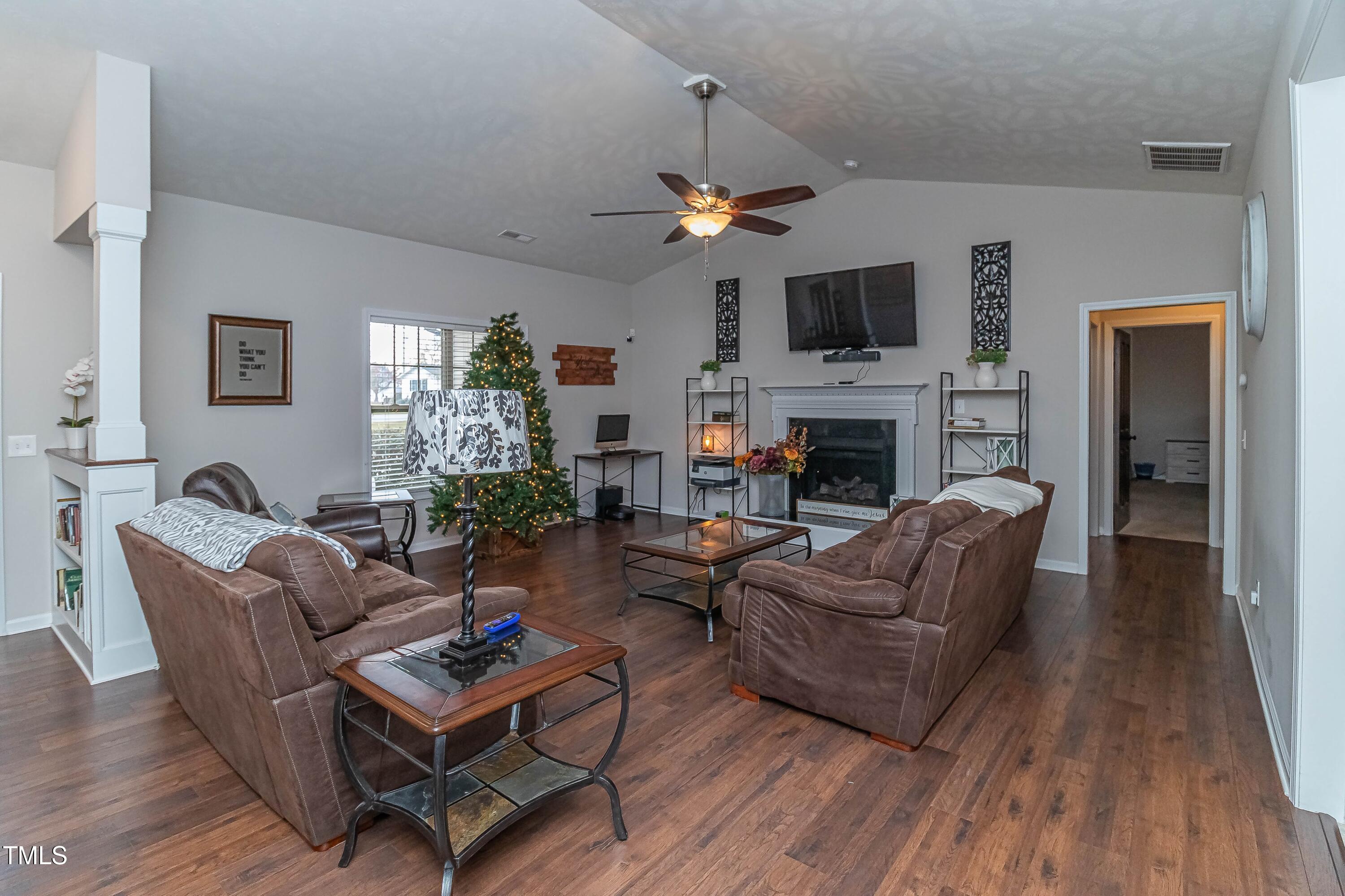 1852 Alderman Mill Road Dunn, NC 28334 - Photo 9 of 36 a living room with furniture a fireplace and a flat screen tv