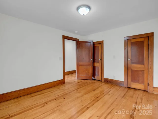 an empty room with wooden floor and closet