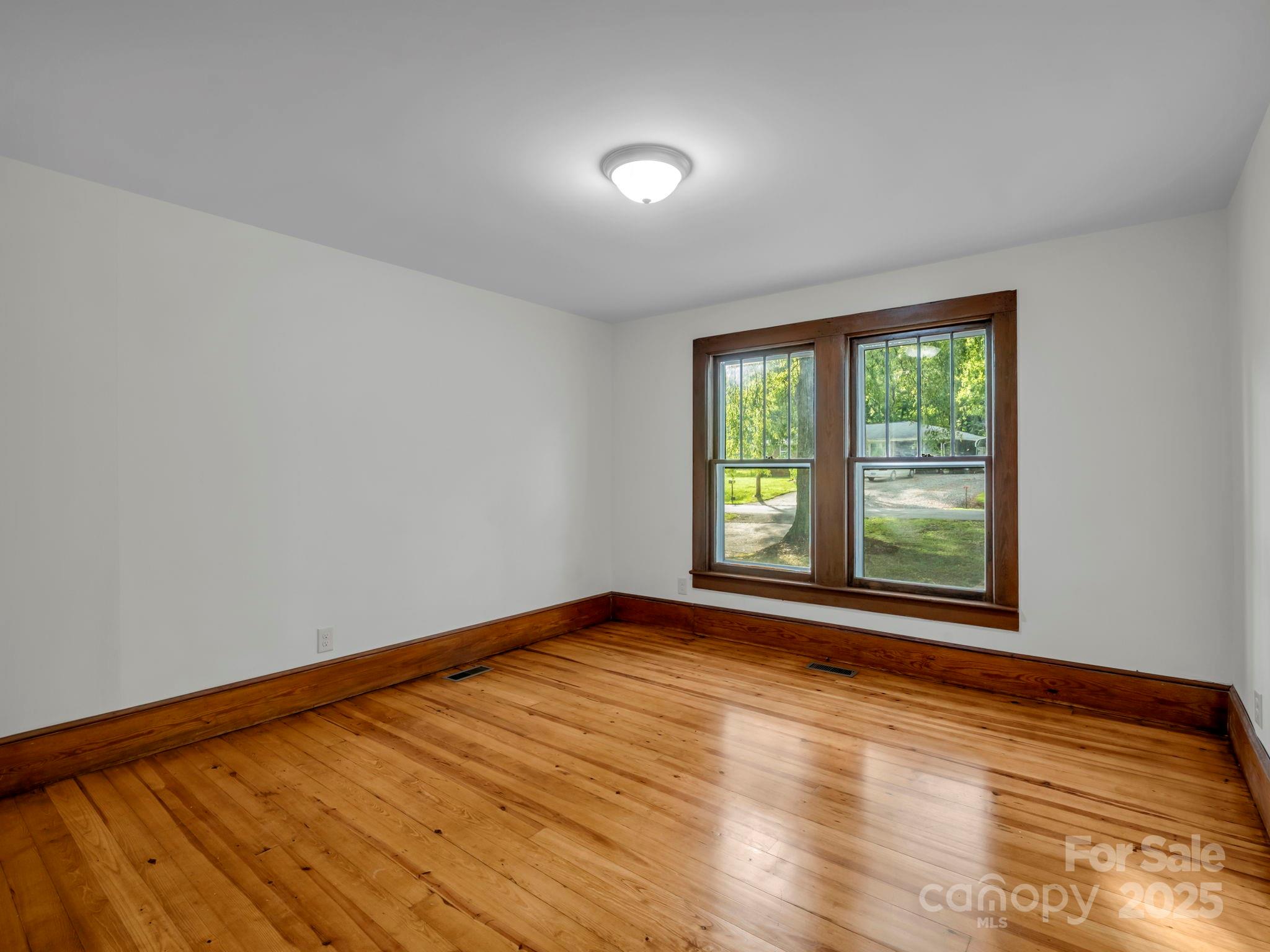 339 Flack Road Forest City, NC 28043 - Photo 15 of 32 a view of an empty room with wooden floor and a window