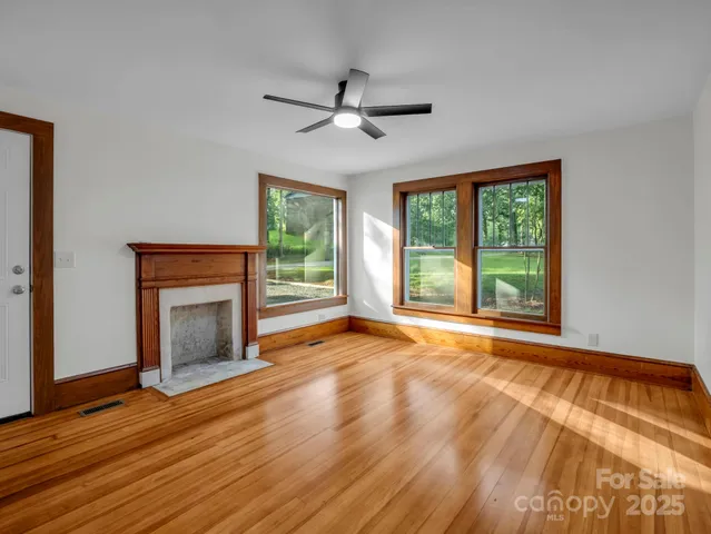 wooden floor fireplace and windows in an empty room