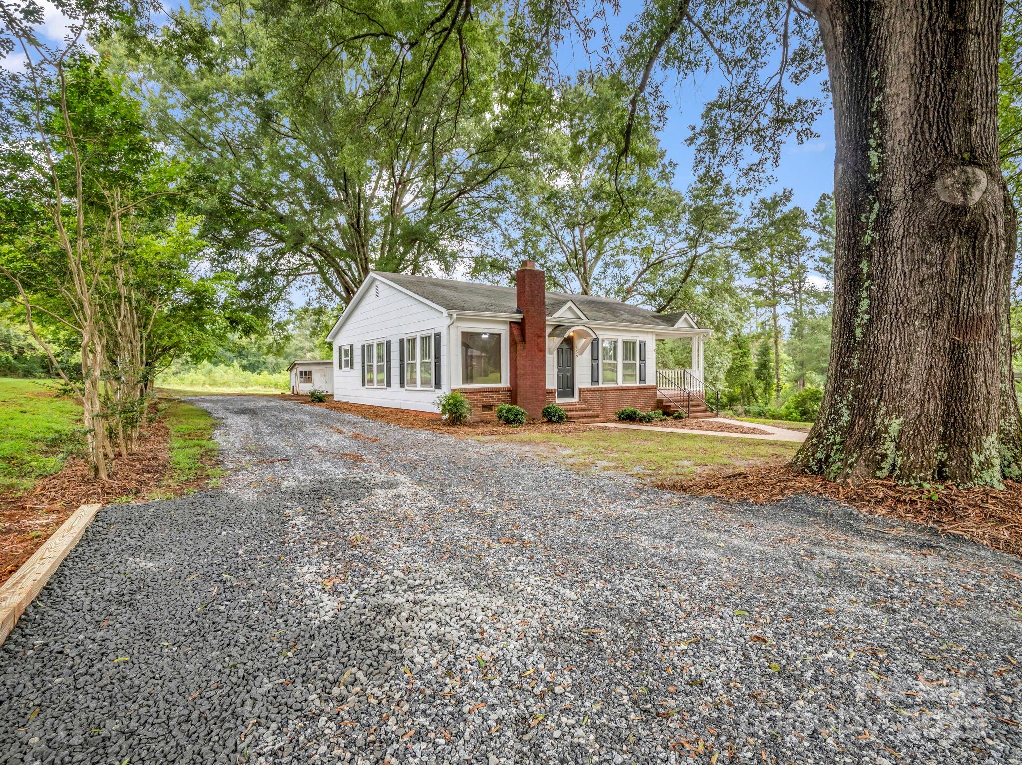 339 Flack Road Forest City, NC 28043 - Photo 2 of 32 a view of house with a big yard and large trees
