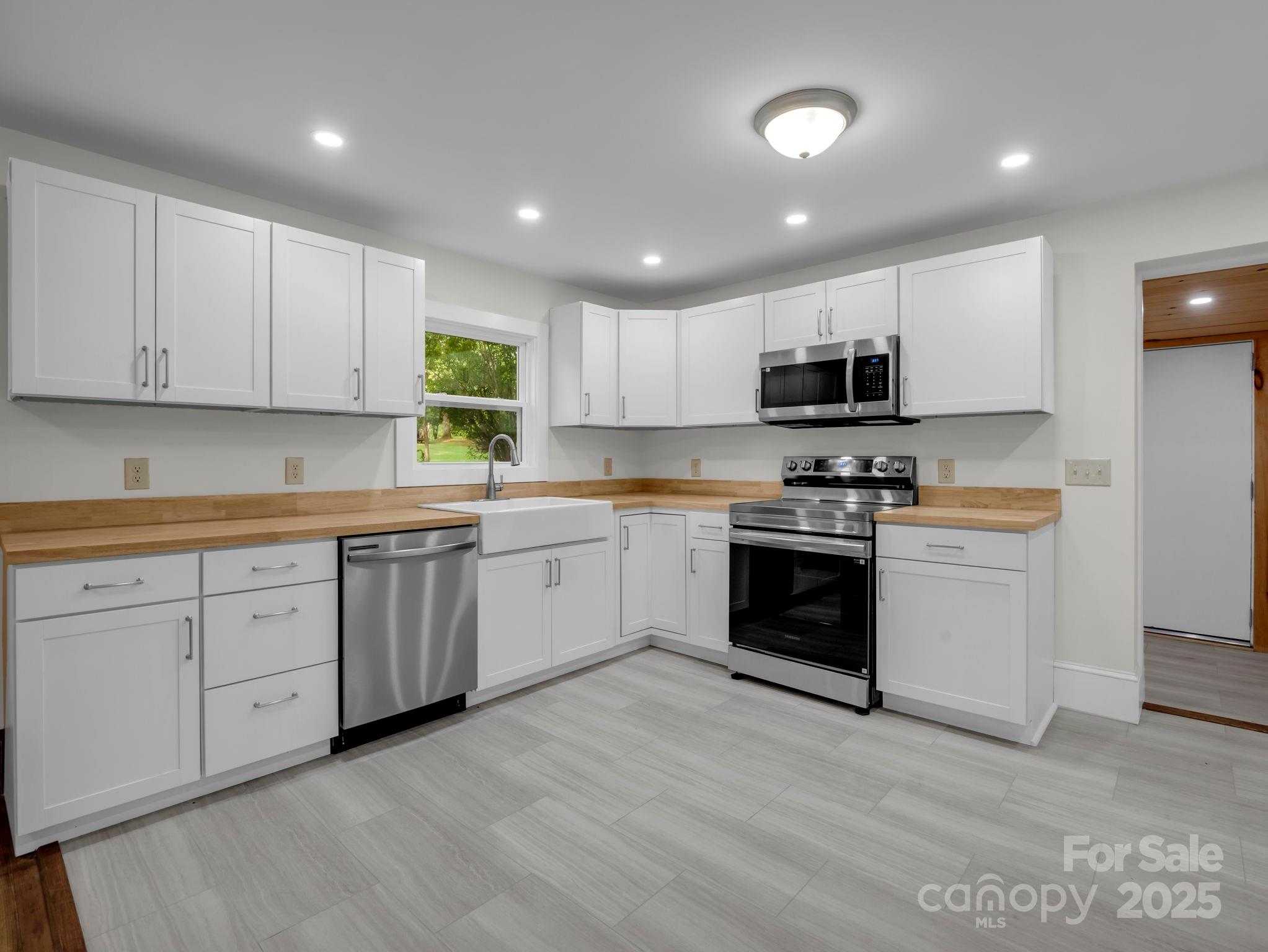 339 Flack Road Forest City, NC 28043 - Photo 23 of 32 a kitchen with sink a microwave and cabinets