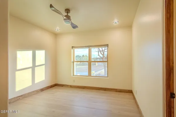 a view of a room with a wooden floor and a ceiling fan