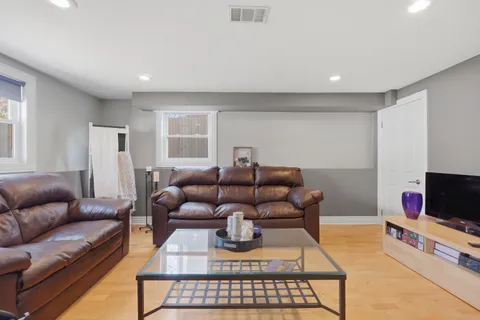 a living room with furniture a flat screen tv and a window