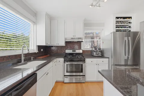 a kitchen with stainless steel appliances granite countertop a stove a sink and a refrigerator