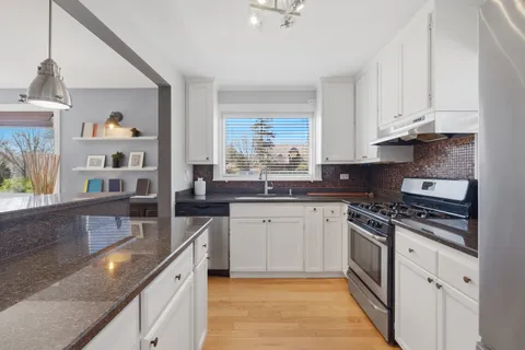 a kitchen with stainless steel appliances granite countertop a stove and a sink