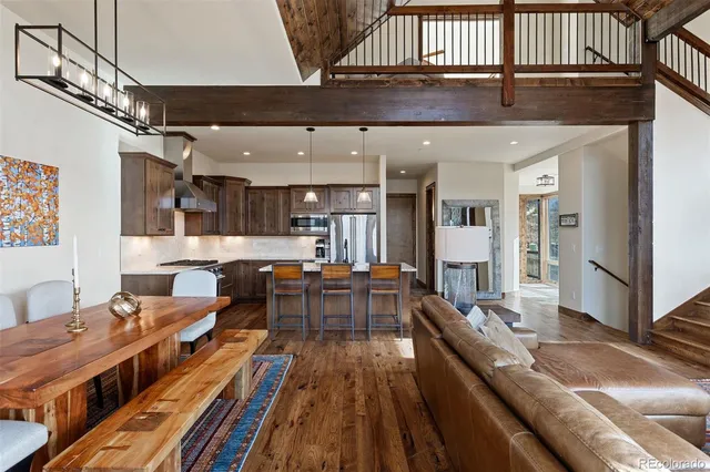 a large living room with stainless steel appliances kitchen island granite countertop furniture and a wooden floor