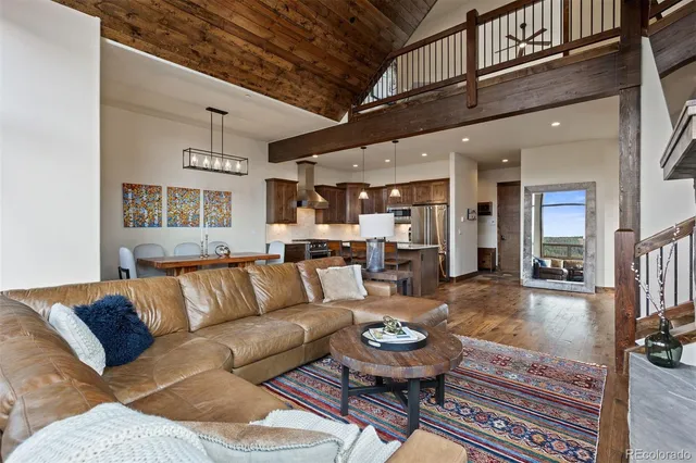 a living room with furniture kitchen view and a large window