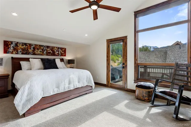 a bedroom with a bed a chandelier and a large window