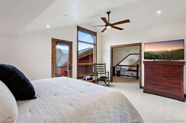 a bedroom with a bed a dresser and flat screen tv