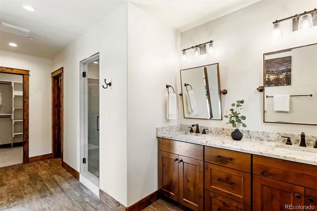 a bathroom with double vanity sink a two mirror a window and a bathtub