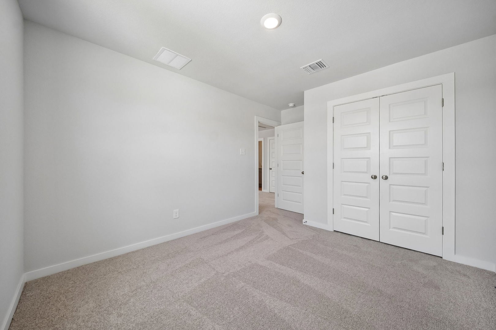 145 Hornet Street Elgin, TX 78621 - Photo 8 of 18 A spacious and neutral secondary bedroom with plush carpeting, perfect for peaceful repose.