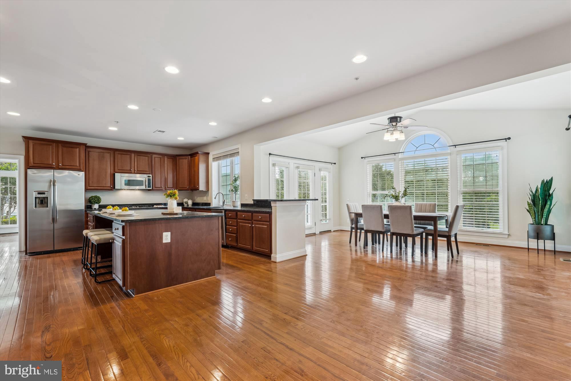 4806 Fair Hill Road Olney, MD 20832 - Photo 20 of 77 a kitchen with stainless steel appliances granite countertop a refrigerator a stove top oven a dining table and chairs with wooden floor
