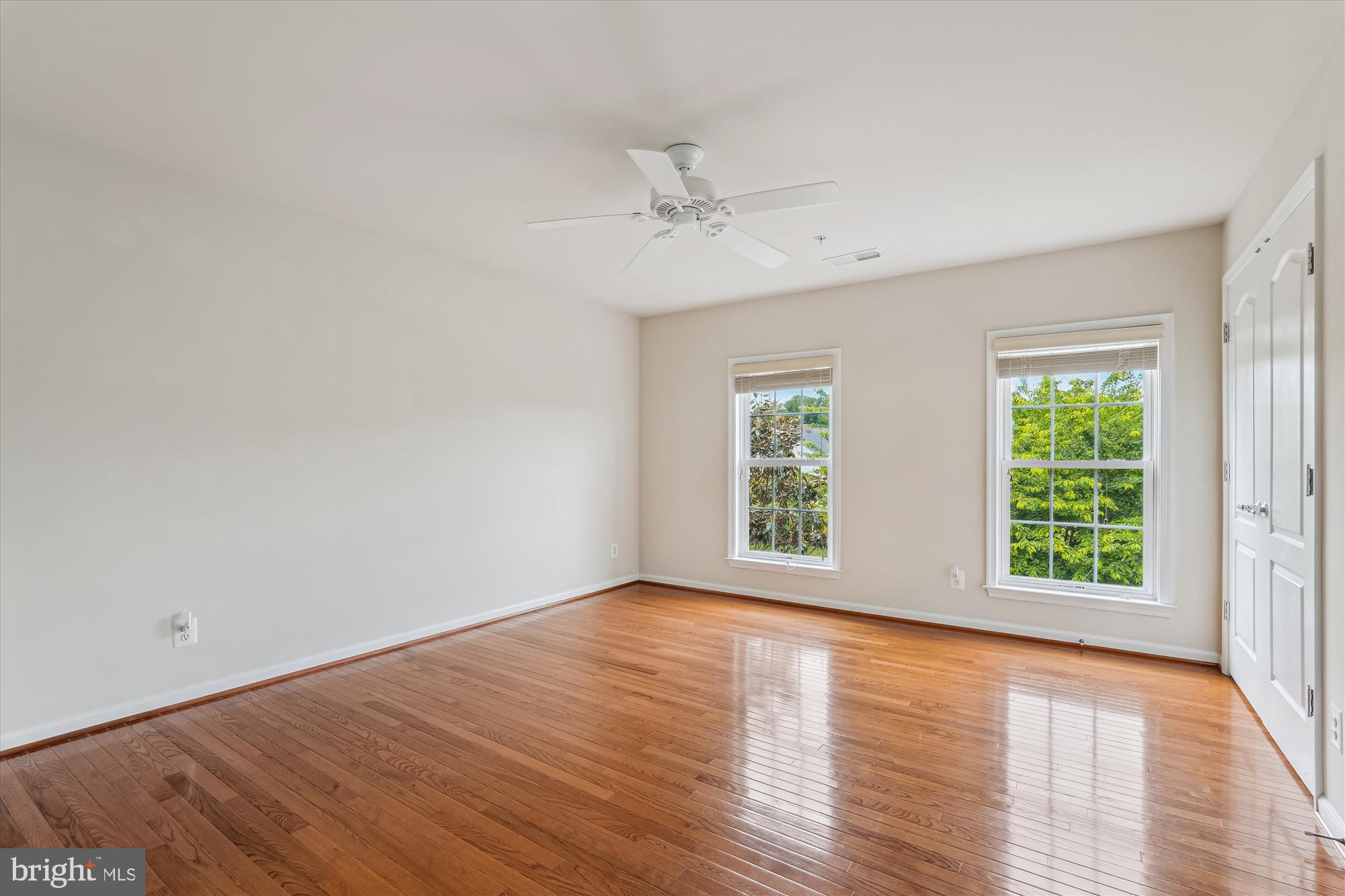 4806 Fair Hill Road Olney, MD 20832 - Photo 56 of 77 an empty room with wooden floor ceiling fan and windows