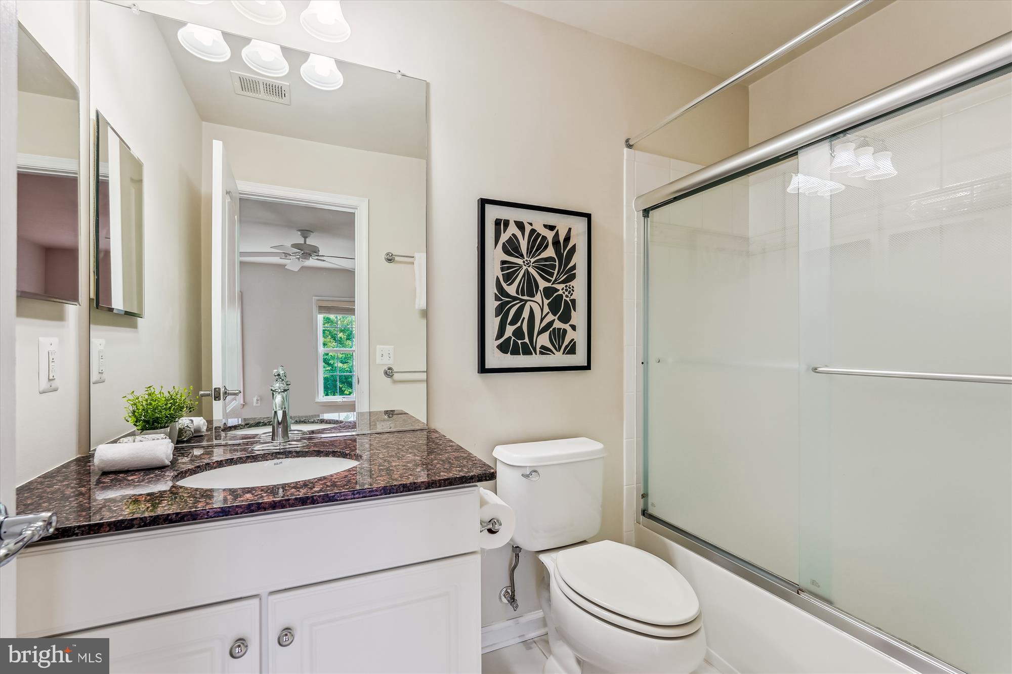 4806 Fair Hill Road Olney, MD 20832 - Photo 58 of 77 a bathroom with a granite countertop sink a toilet and a mirror
