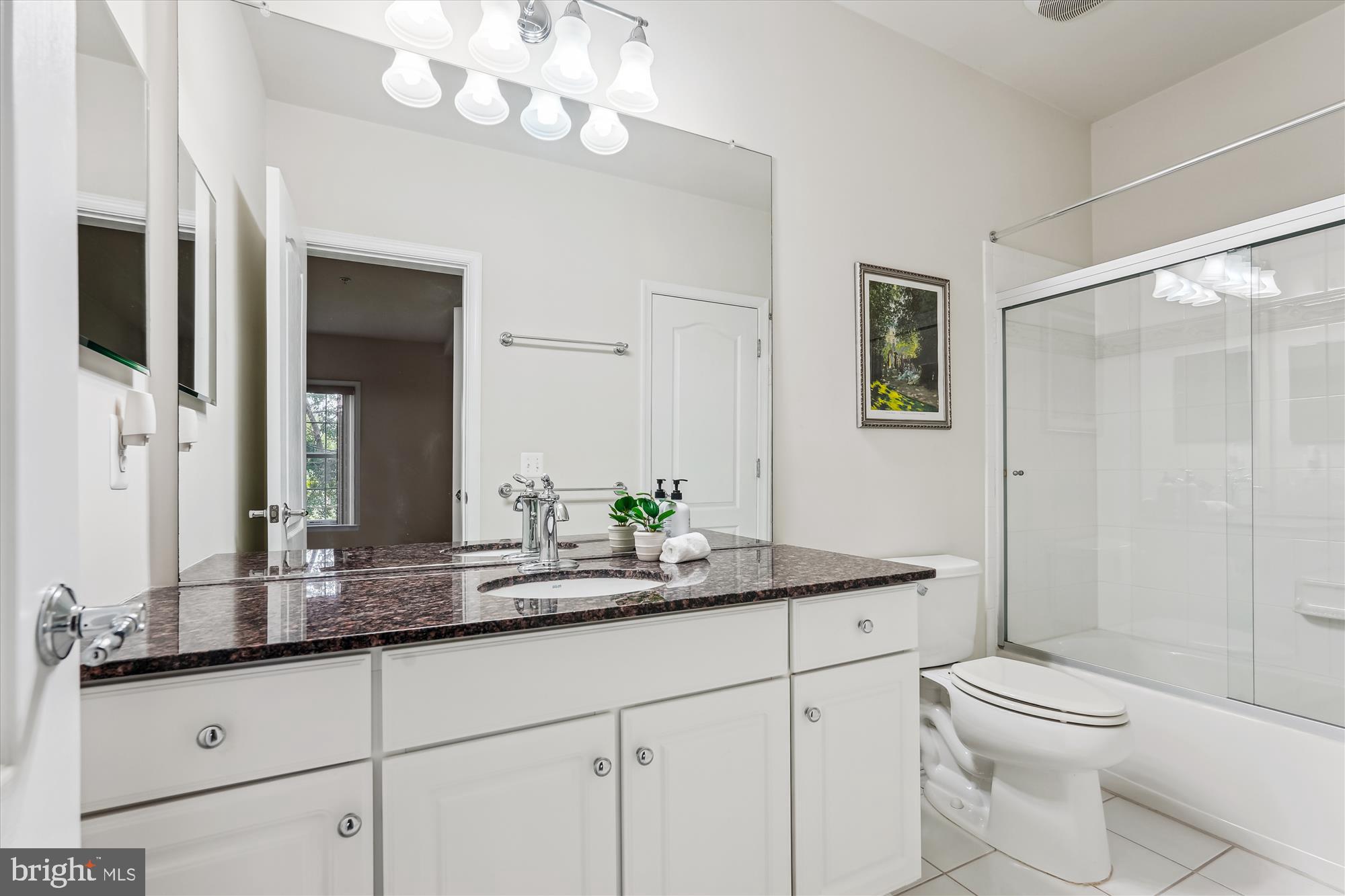 4806 Fair Hill Road Olney, MD 20832 - Photo 68 of 77 a bathroom with a granite countertop sink a toilet a mirror and shower