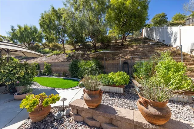 a view of a backyard with chair and the garden