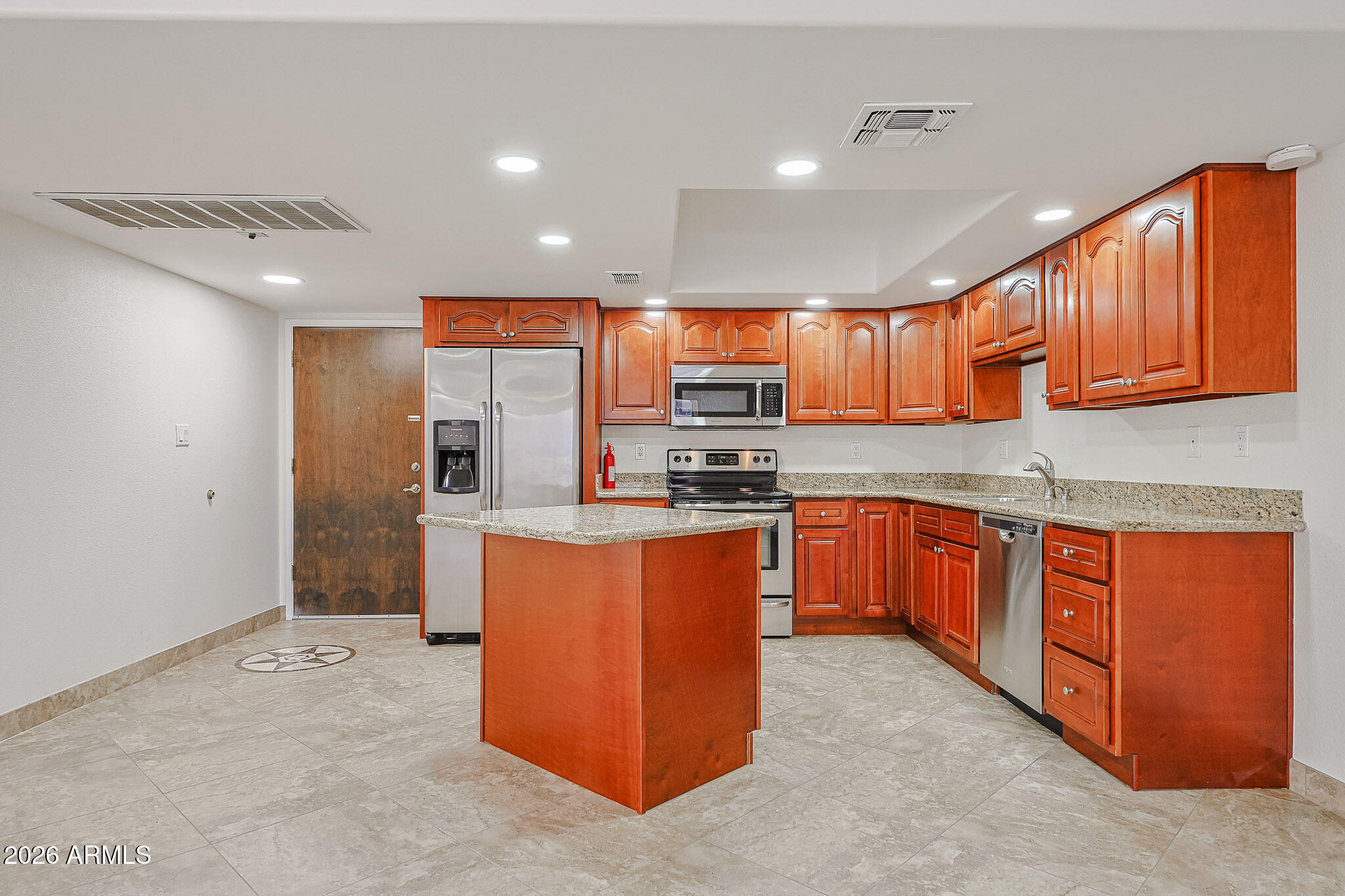 7920 East Camelback Road, Unit 111 Scottsdale, AZ 85251 - Photo 5 of 32 a kitchen with stainless steel appliances granite countertop wooden cabinets a stove a sink and a refrigerator