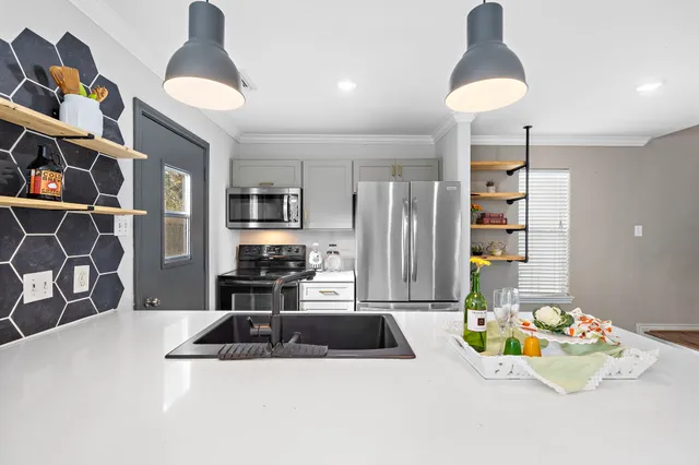 a kitchen with stainless steel appliances a sink a table and chairs