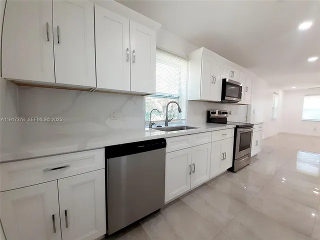 a kitchen with stainless steel appliances granite countertop white cabinets sink and dishwasher
