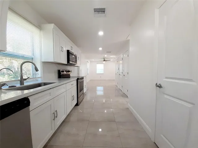 a kitchen with stainless steel appliances a sink stove and cabinets