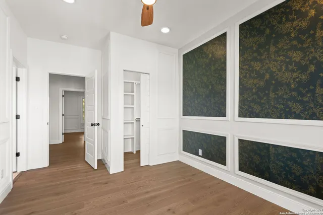 a view of an empty room with wooden floor and a fireplace