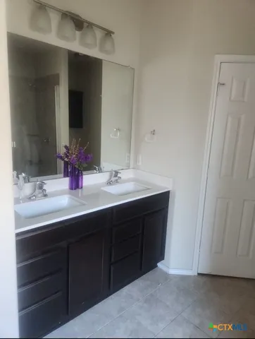 a bathroom with a double vanity sink and large mirror