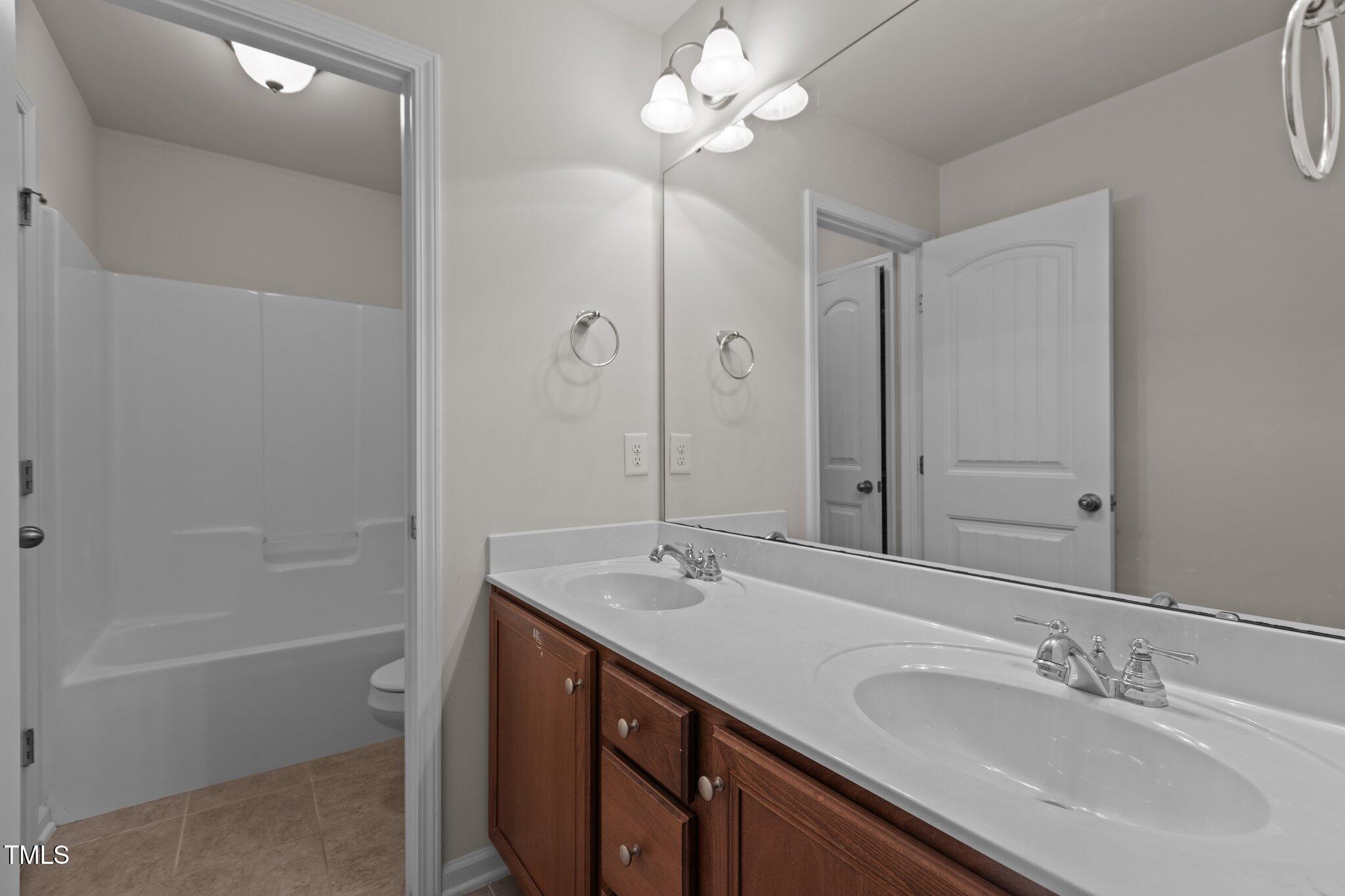 2082 Weston Green Loop Cary, NC 27513 - Photo 35 of 49 a bathroom with a sink a toilet and shower