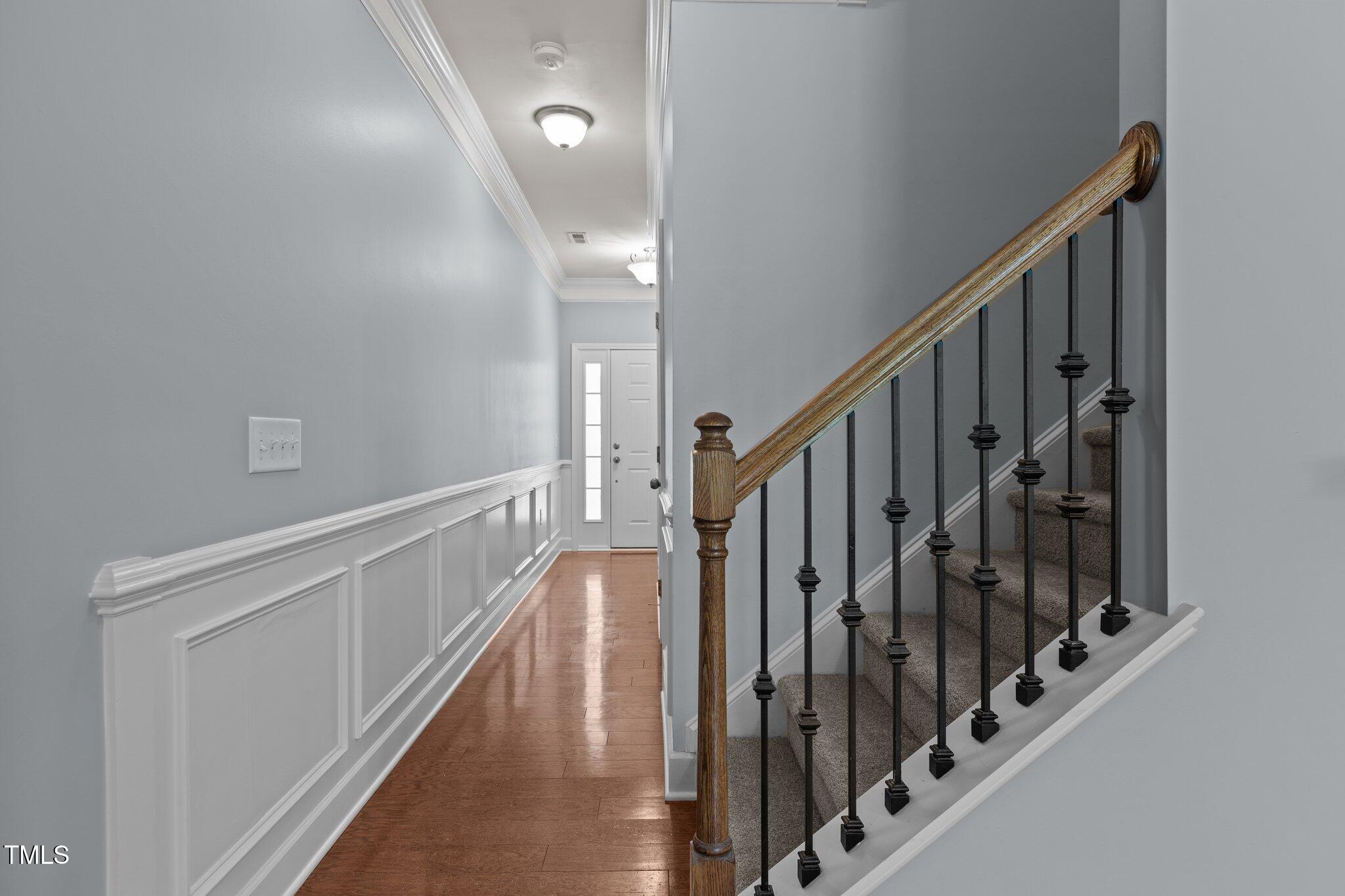 2082 Weston Green Loop Cary, NC 27513 - Photo 6 of 49 a view of staircase with lots of frames on wall and wooden floor