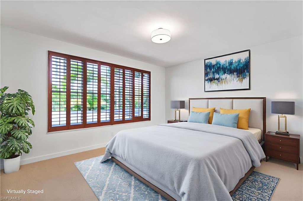 8169 Via Vecchia Naples, FL 34108 - Photo 13 of 33 a bedroom with a large bed and a painting on the wall